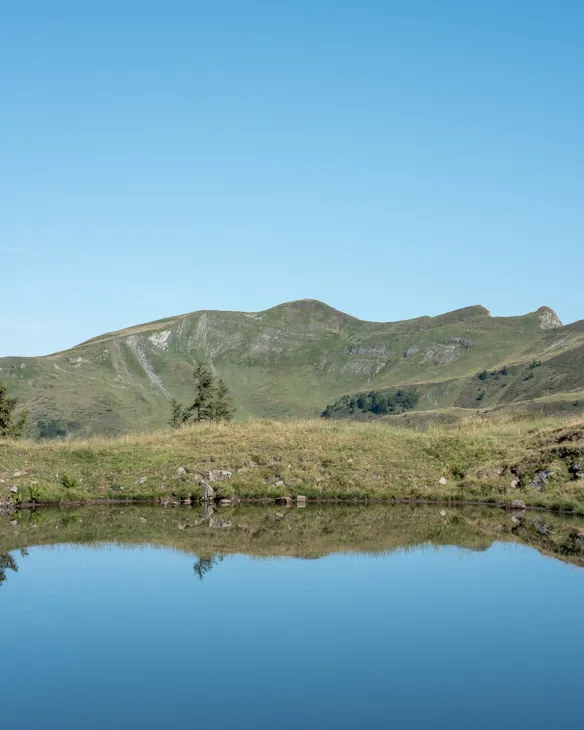Blick vom Ufer des Blauen Sees auf die Sünser Spitze bei Damüls.